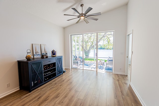 spare room featuring lofted ceiling, a ceiling fan, baseboards, and wood finished floors