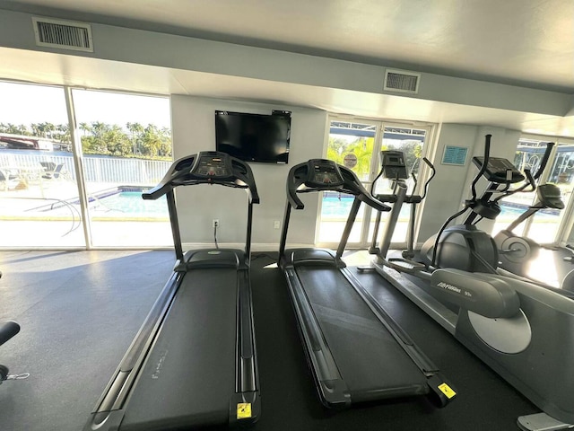 workout area with baseboards, visible vents, and a healthy amount of sunlight