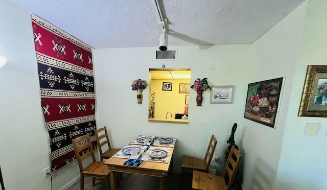 dining room with visible vents and a textured ceiling