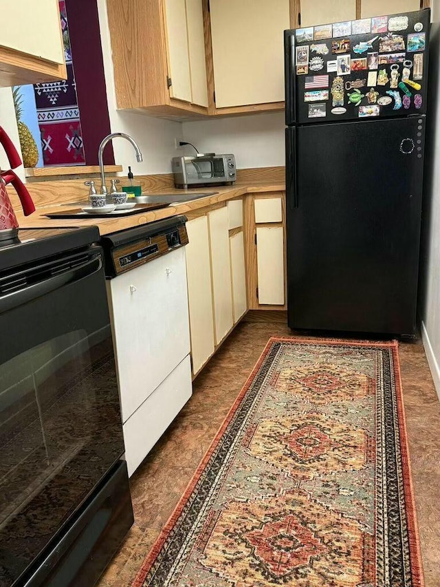 kitchen featuring black appliances, a toaster, light countertops, and a sink