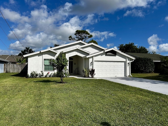 view of front of property with a garage, a front yard, fence, and driveway