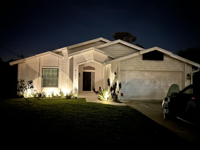 view of front of house featuring a garage, concrete driveway, and a yard