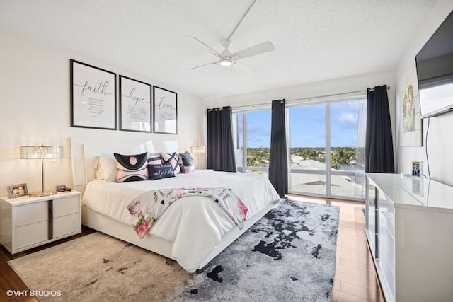 bedroom with access to exterior, ceiling fan, a textured ceiling, and light wood-style floors