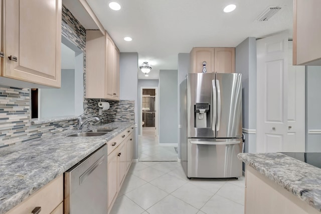 kitchen with light tile patterned floors, a sink, visible vents, appliances with stainless steel finishes, and decorative backsplash