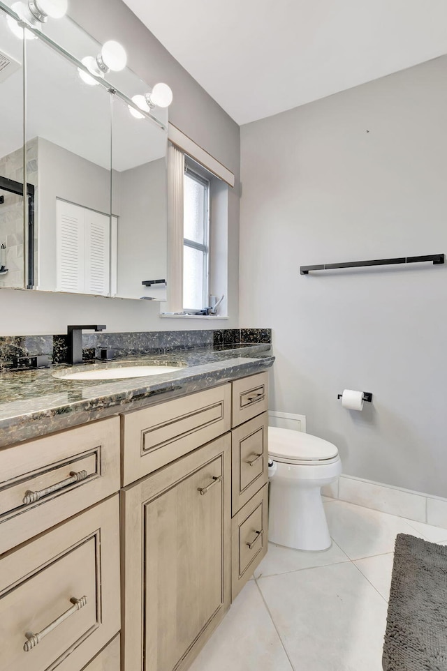 full bathroom with baseboards, vanity, toilet, and tile patterned floors