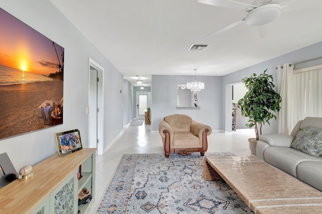 living room featuring light tile patterned floors, ceiling fan with notable chandelier, visible vents, and baseboards