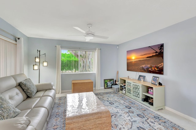 living room featuring ceiling fan, tile patterned floors, and baseboards