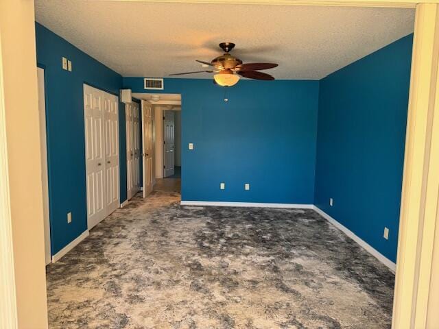 unfurnished bedroom featuring carpet flooring, baseboards, visible vents, and a textured ceiling