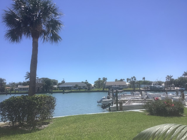 view of dock with a yard and a water view