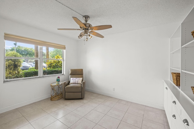 unfurnished room with light tile patterned floors, baseboards, a textured ceiling, and a ceiling fan