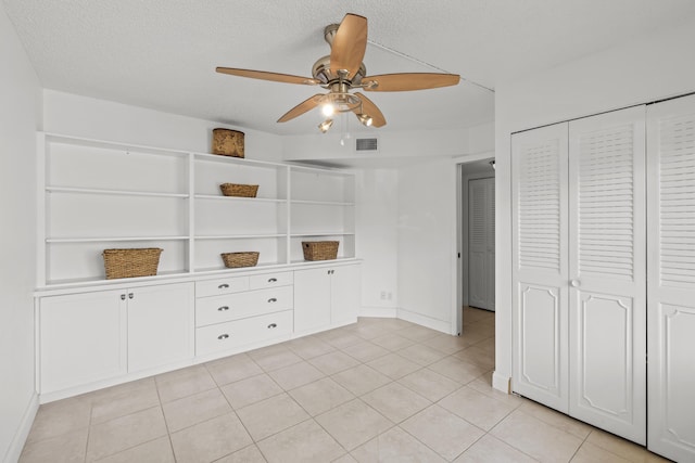 unfurnished bedroom featuring a ceiling fan, visible vents, a closet, and a textured ceiling