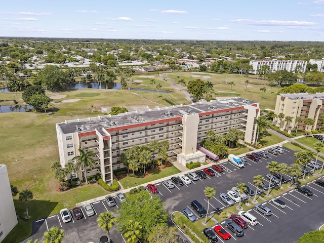 drone / aerial view with golf course view and a water view