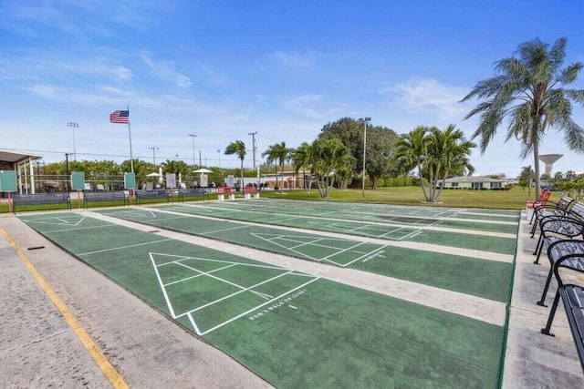 view of property's community with shuffleboard and fence