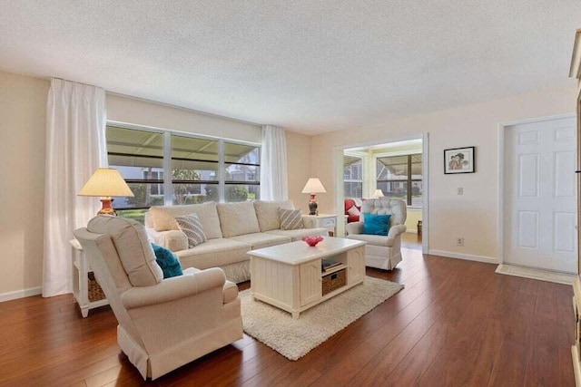 living room with a wealth of natural light, dark wood-style flooring, and a textured ceiling