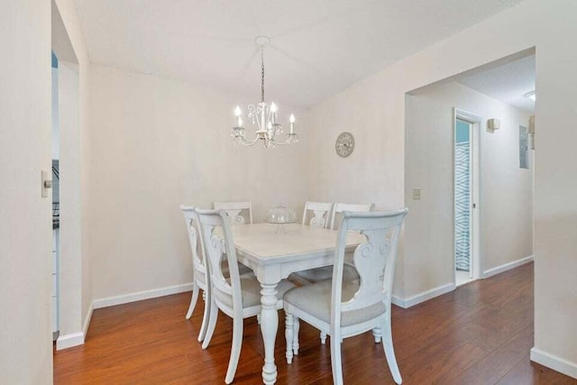 dining room with a notable chandelier, baseboards, and wood finished floors