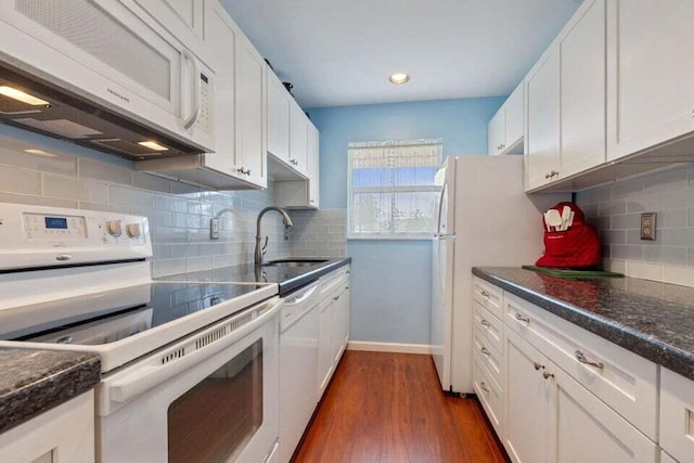 kitchen featuring white appliances, white cabinetry, dark wood-type flooring, and a sink