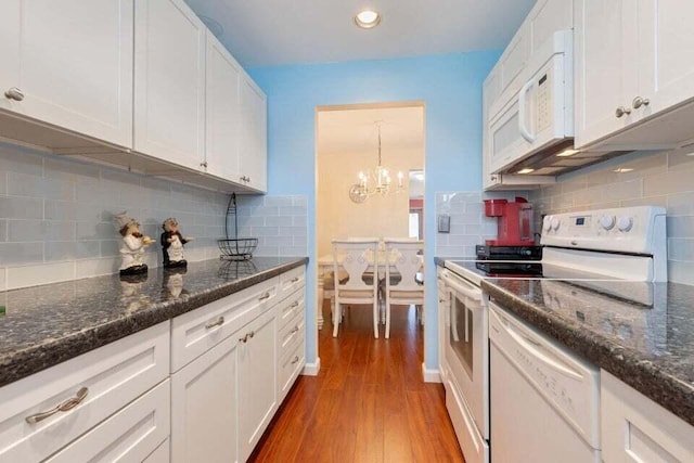 kitchen with dark wood finished floors, tasteful backsplash, white cabinetry, dark stone counters, and white appliances