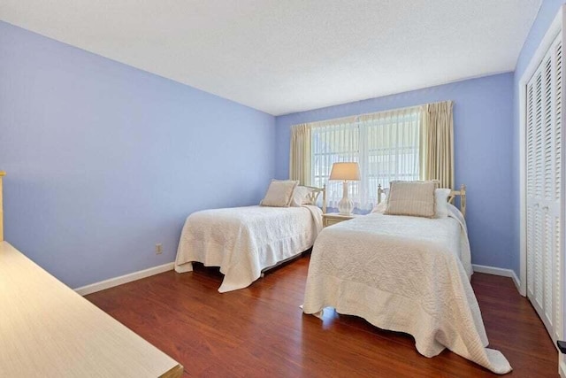 bedroom featuring a closet, wood finished floors, and baseboards