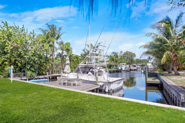 dock area with a yard and a water view