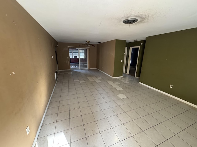 empty room with visible vents, ceiling fan, a textured ceiling, and baseboards