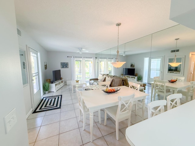 dining room with light tile patterned floors, ceiling fan, a textured ceiling, and visible vents