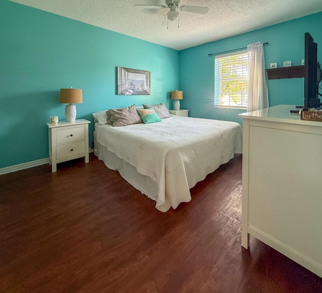 bedroom featuring baseboards, a textured ceiling, a ceiling fan, and dark wood-style flooring