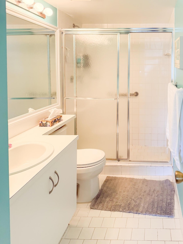 full bathroom with toilet, a shower stall, tile patterned flooring, and vanity