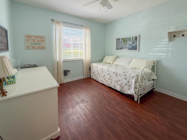 bedroom featuring a textured ceiling, ceiling fan, dark wood finished floors, and baseboards