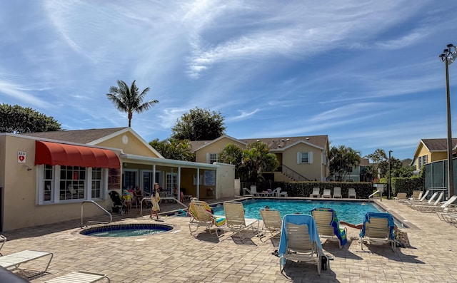 community pool with a community hot tub, a patio area, and fence