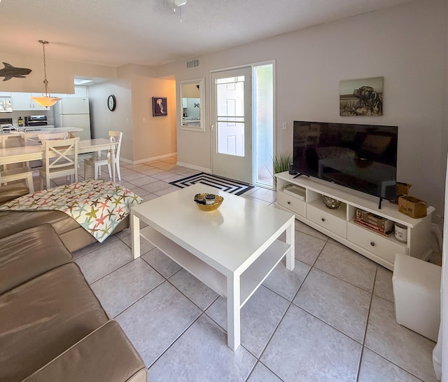 living area with visible vents, baseboards, and light tile patterned flooring