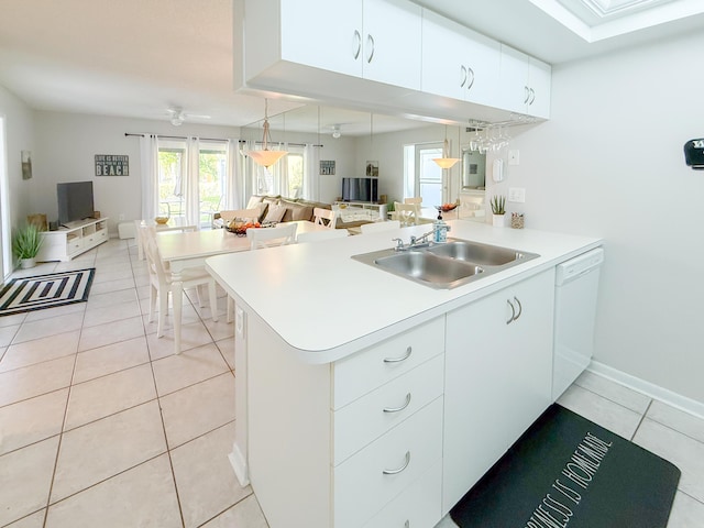 kitchen with light tile patterned floors, a peninsula, a sink, light countertops, and dishwasher