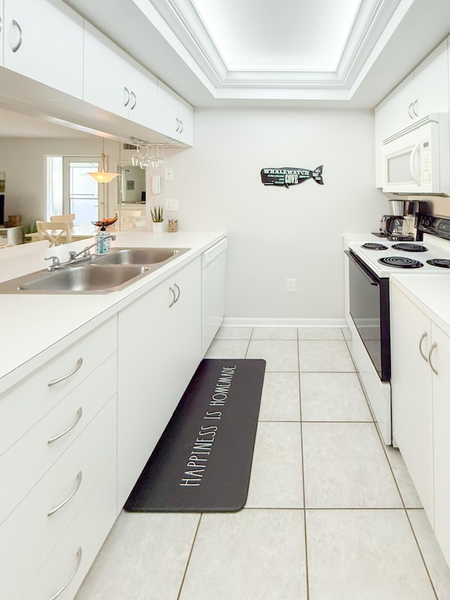 kitchen featuring crown molding, white appliances, a raised ceiling, and a sink