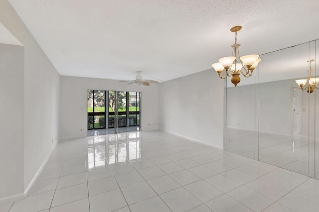 unfurnished room featuring ceiling fan with notable chandelier, baseboards, a textured ceiling, and light tile patterned flooring