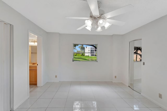 spare room featuring light tile patterned floors and ceiling fan