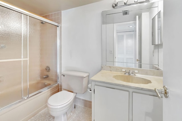 bathroom with tile patterned flooring, shower / bath combination with glass door, vanity, and toilet