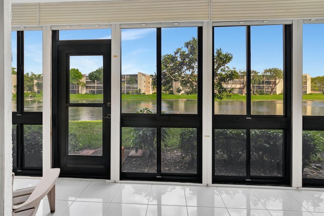 entryway featuring a water view, tile patterned floors, and plenty of natural light