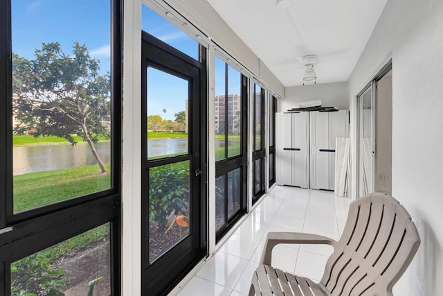 sunroom featuring a water view