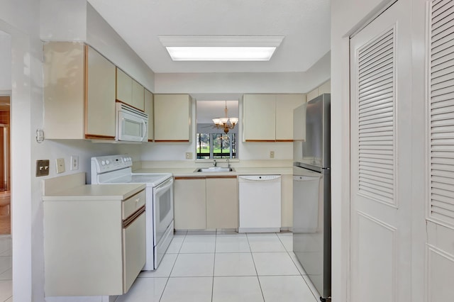 kitchen featuring white appliances, light tile patterned floors, an inviting chandelier, cream cabinets, and light countertops