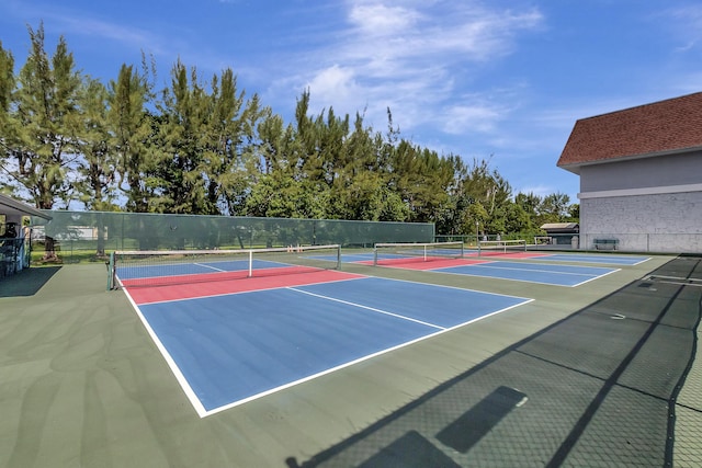 view of tennis court featuring community basketball court and fence