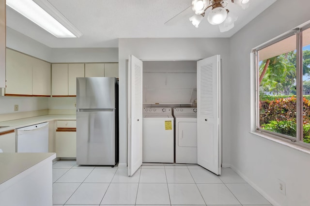 kitchen with freestanding refrigerator, washer and clothes dryer, cream cabinets, dishwasher, and light countertops