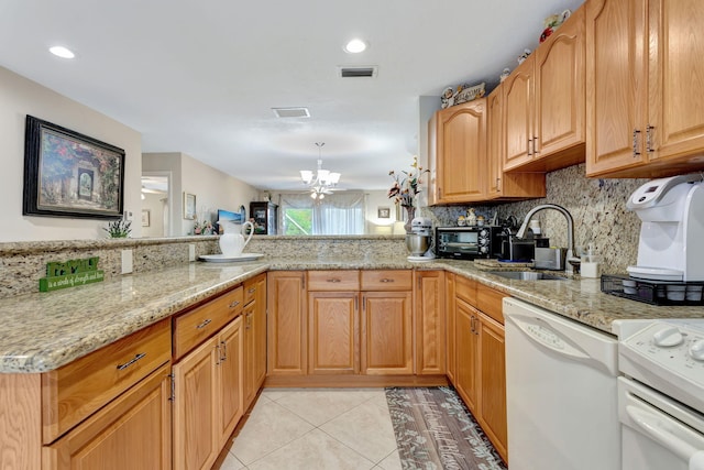 kitchen with light stone counters, light tile patterned floors, visible vents, a sink, and white appliances