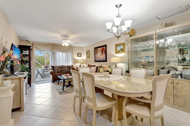 dining area featuring light tile patterned floors, visible vents, and ceiling fan with notable chandelier