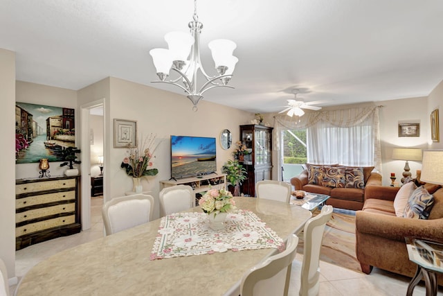 dining area featuring light tile patterned floors and ceiling fan with notable chandelier