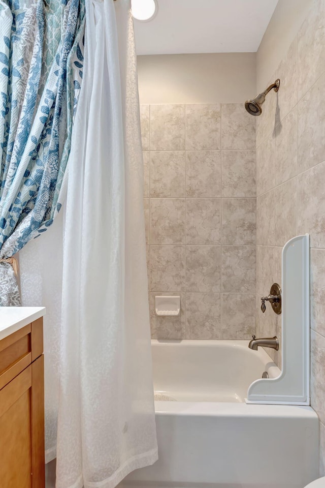 bathroom featuring vanity and shower / bathtub combination with curtain