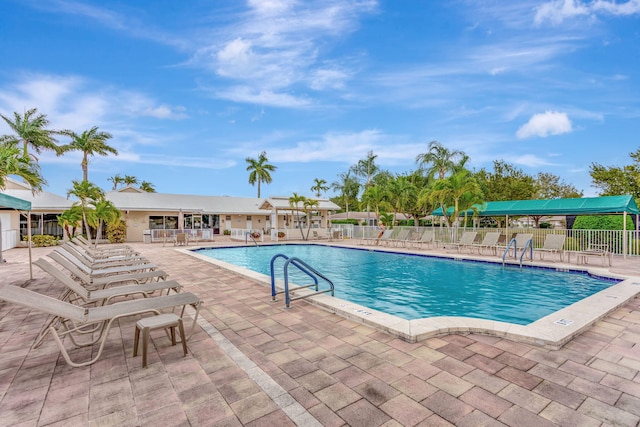 community pool with a patio and fence