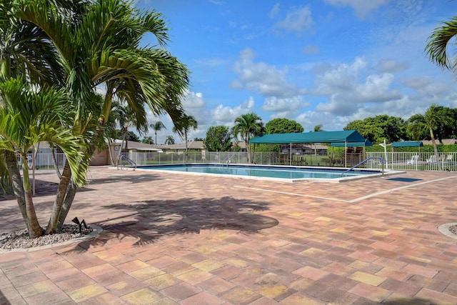 community pool featuring fence and a patio