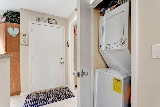 laundry area with laundry area, stacked washer and clothes dryer, and light tile patterned floors