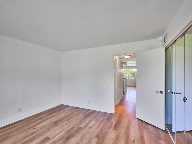 unfurnished room with baseboards, visible vents, and light wood-style floors