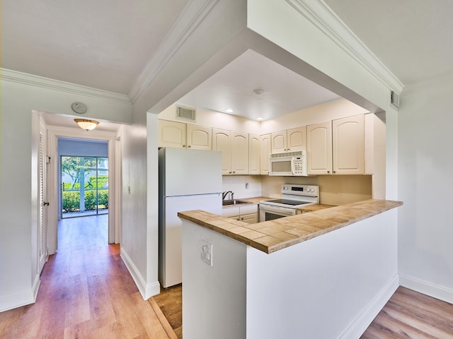 kitchen featuring white appliances, visible vents, light wood-style flooring, a peninsula, and crown molding