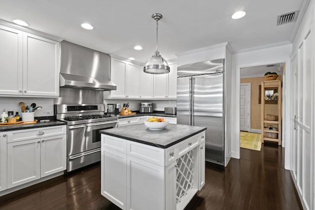 kitchen with visible vents, dark countertops, appliances with stainless steel finishes, wall chimney exhaust hood, and dark wood-style flooring